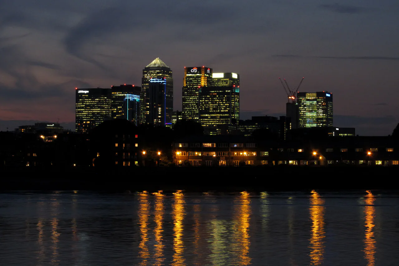 The Canary Wharf towers lit at dusk across the river from Greenwich