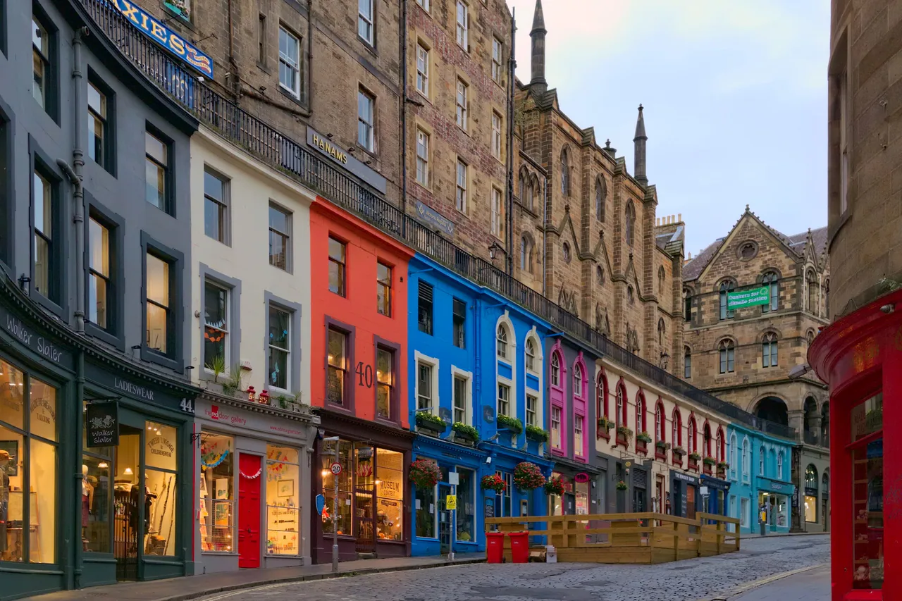 The curving, colourful shopfronts of Victoria Street in Edinburgh in early light