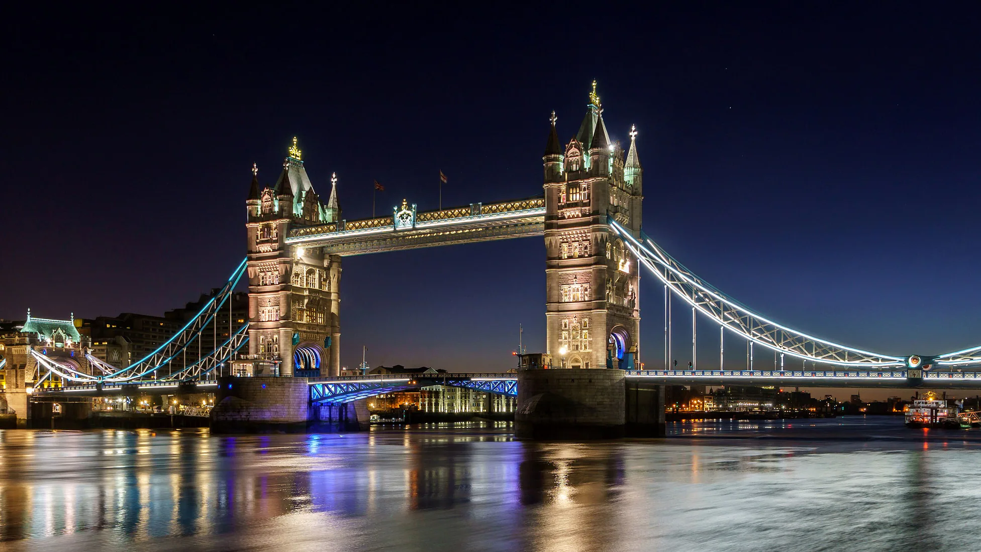 Tower Bridge against a pale pink dawn sky over the Thames in winter